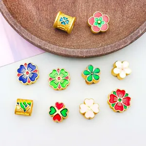 Detailed view of 10 colorful enamel flower and clover spacer beads for DIY jewelry
