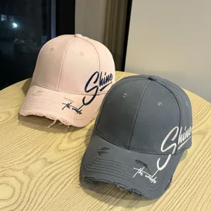 Detailansicht lässiger Baseballcaps mit ausgefranstem Schirm und cooler Stickerei.