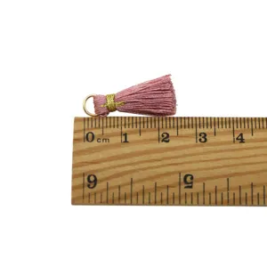 Detailed view of a 2.5cm pink vintage tassel pendant measured on a wooden ruler for DIY crafts.
