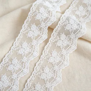 Dettaglio in primo piano di merletto ricamato in cotone bianco 8cm, ideale per cucito e DIY.