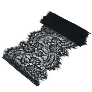 Black lace fabric detail close up showing exquisite floral pattern and delicate eyelash trim.