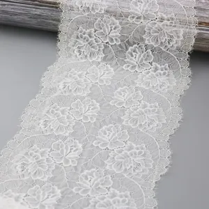 Detailed close-up view of white floral stretch lace trim, ideal for sewing and DIY crafts.