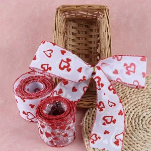 Gros plan sur le ruban décoratif à bord filaire avec motif de cœur rouge, texture et nœud.