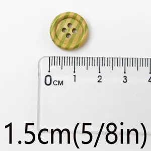 Close-up detail of 1.5cm round 4-hole wooden button with green stripe for sewing crafts.