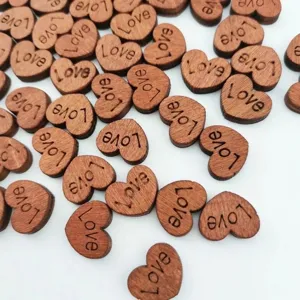 Close-up detail view of small wooden heart buttons with engraved love text for DIY crafts.