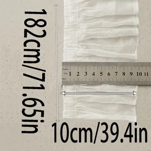 Detailed close-up of white pleated chiffon lace trim, showing texture and width with ruler.