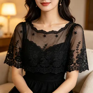 Detail view of black mesh lace embroidered fabric trim showing fine craftsmanship and texture.