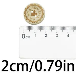 Detailed view of a 2cm 2-hole wooden button with heart engraving and size reference ruler.