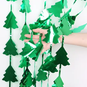 Green metallic Christmas tree hanging curtain detail, shiny foil party decoration backdrop.