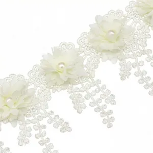 White lace trim detail with fabric flowers and faux pearls for DIY sewing and crafts.