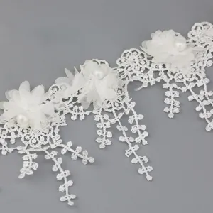 Detailed view of white lace trim with chiffon flowers and pearls, ideal for crafts and sewing.