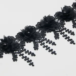 Detailed shot of black 3D flower lace trim, featuring delicate pearl beads and hanging leaves.