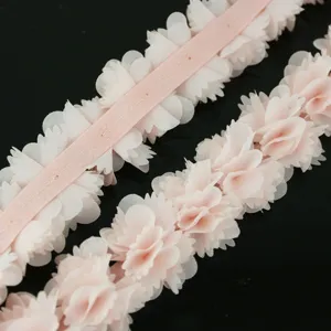 Dettaglio bordo in pizzo di chiffon a fiori, nastro rosa per cucito, confezioni e decori.