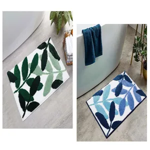 Detail view of tufted leaf pattern bathroom floor mats shown in green and blue color variants.