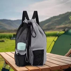 Detailed view of grey drawstring backpack with mesh side pocket on wooden table outdoors.