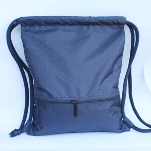 Close-up detail of dark blue nylon drawstring backpack with honeycomb pattern and zipper pocket.