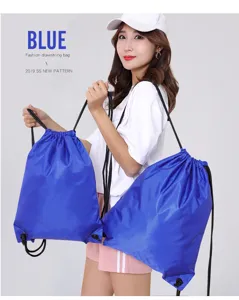 Detail view of blue oxford drawstring gym backpack held by model, ideal for sports and outdoor.