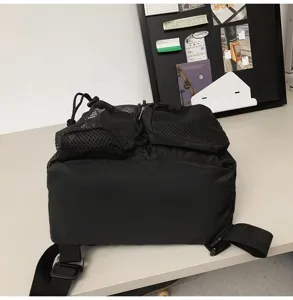 Detailed view of black drawstring backpack with breathable mesh pockets for sports.
