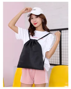 Detail view of the black waterproof oxford cloth drawstring backpack with soccer pattern.