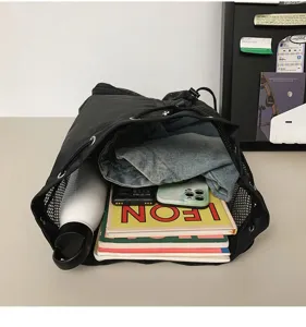 Outdoor black mesh drawstring backpack detail showing large capacity storage and items.