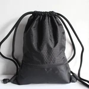 Detail of black drawstring backpack with honeycomb texture and front zipper pocket for gym.