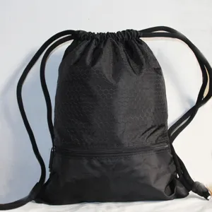 Black nylon drawstring backpack detail showing honeycomb pattern and front zipper pocket.