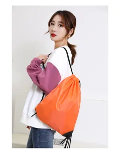 Gedetailleerd overzicht van een oranje polyester trekkoord rugzak gedragen door model, duurzame tas.