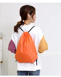 Heldere oranje polyester trekkoord rugzak, gedragen op de rug voor dagelijks buitengebruik.