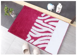 Vue détaillée du tapis de bain touffeté doux avec motif rose et blanc chic pour le sol.