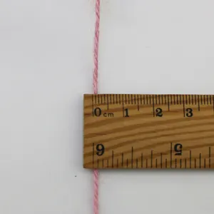 Detailopname van 3mm roze jute touw met houten liniaal voor handwerk en creatieve decoratie.
