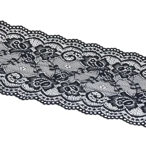 Close-up view of black elastic lace trim detail, showing floral pattern and scalloped edge.