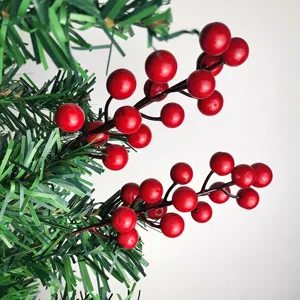 Close-up of artificial red berries Christmas tree ornament detail branch holiday party decor