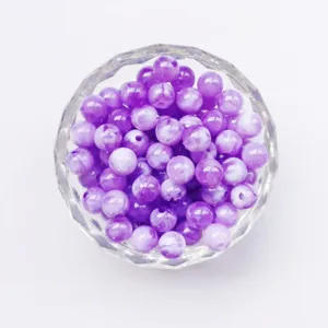 Close-up detail of purple marbled acrylic round loose beads for diy jewelry accessories.