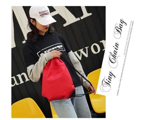 Red nylon drawstring backpack detail, lightweight sports gym bag and casual travel sack.