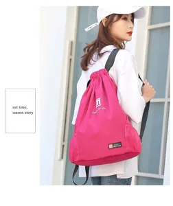 Detail view of the pink drawstring sports backpack with side mesh pockets and shoulder straps.