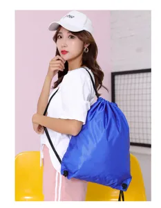 Detail shot of the blue oxford cloth drawstring backpack showing shoulder straps and fabric.