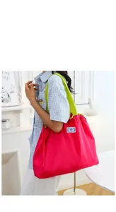 Grand sac de shopping pliable rose et écologique avec bretelles vertes, vue de détail.