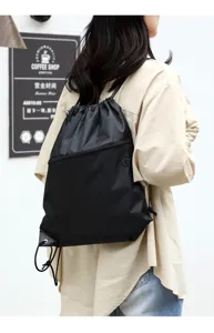 Detailansicht des schwarzen Nylon-Kordelzug-Rucksacks am Model mit Reißverschlusstasche.