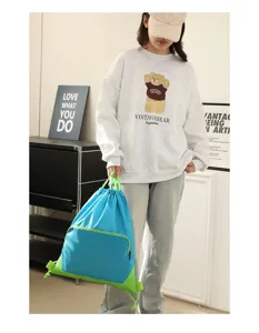 Waterproof blue drawstring backpack with green straps, casual gym and sports bag detail view.