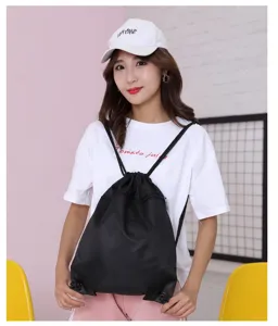 Detail view of black drawstring backpack, lightweight portable design for outdoor sports and daily use.