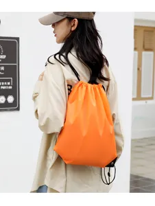 Orange drawstring backpack detail view, lightweight polyester sports storage bag for daily use.