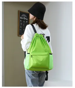 Green oxford cloth drawstring backpack with front pocket and mesh side storage bags.