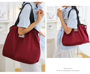Detailansicht der leichten faltbaren Einkaufstasche und Wickeltasche auf der Schulter.