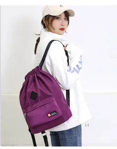 Lightweight purple drawstring backpack for sports, travel, and fitness use with front pocket.
