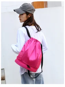 Pink drawstring swim backpack with wet dry compartment and mesh side pockets worn by model