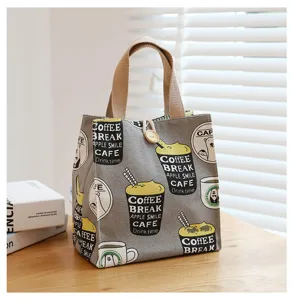 Grey canvas lunch bag detail showing cute coffee cup and bear print design with sturdy handles.