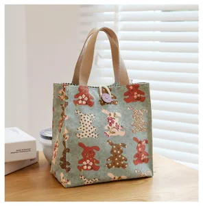 Canvas lunch bag detail showcasing cute bear and rabbit floral prints with sturdy handles.