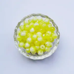 Detailed 6mm yellow white swirl acrylic loose beads in a clear bowl for DIY jewelry making.