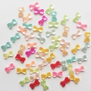 Gros plan de breloques nœud en perle ABS colorée pour nail art et bricolages DIY.