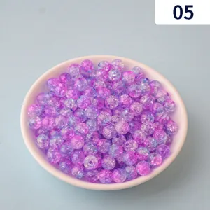 Close-up detail of purple and blue crackle acrylic beads in a bowl for DIY jewelry.